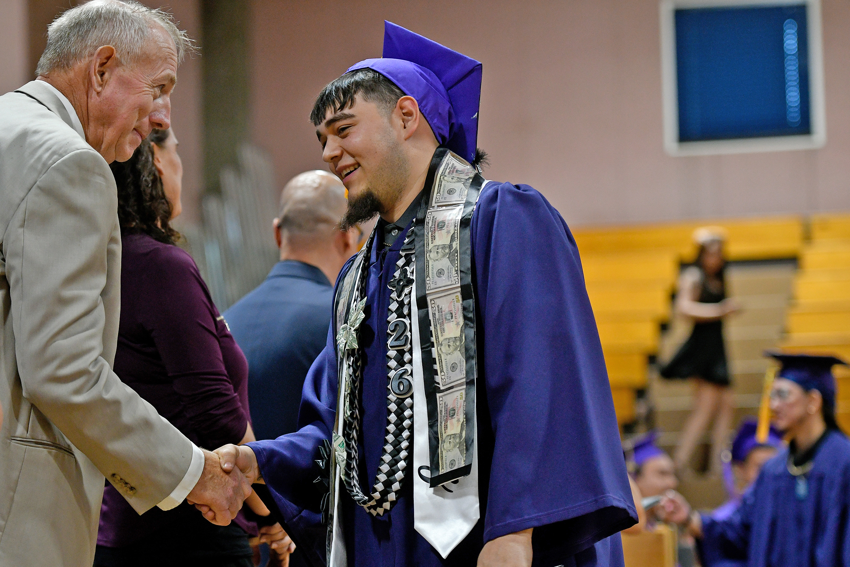 Board of Regents Chair Martin shaking a graduates hand 